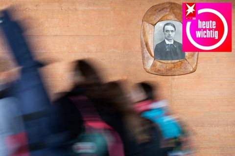 Schülerinnen gehen in der Freien Waldorfschule Uhlandshöhe an einem Bild von Rudolf Steiner vorbei