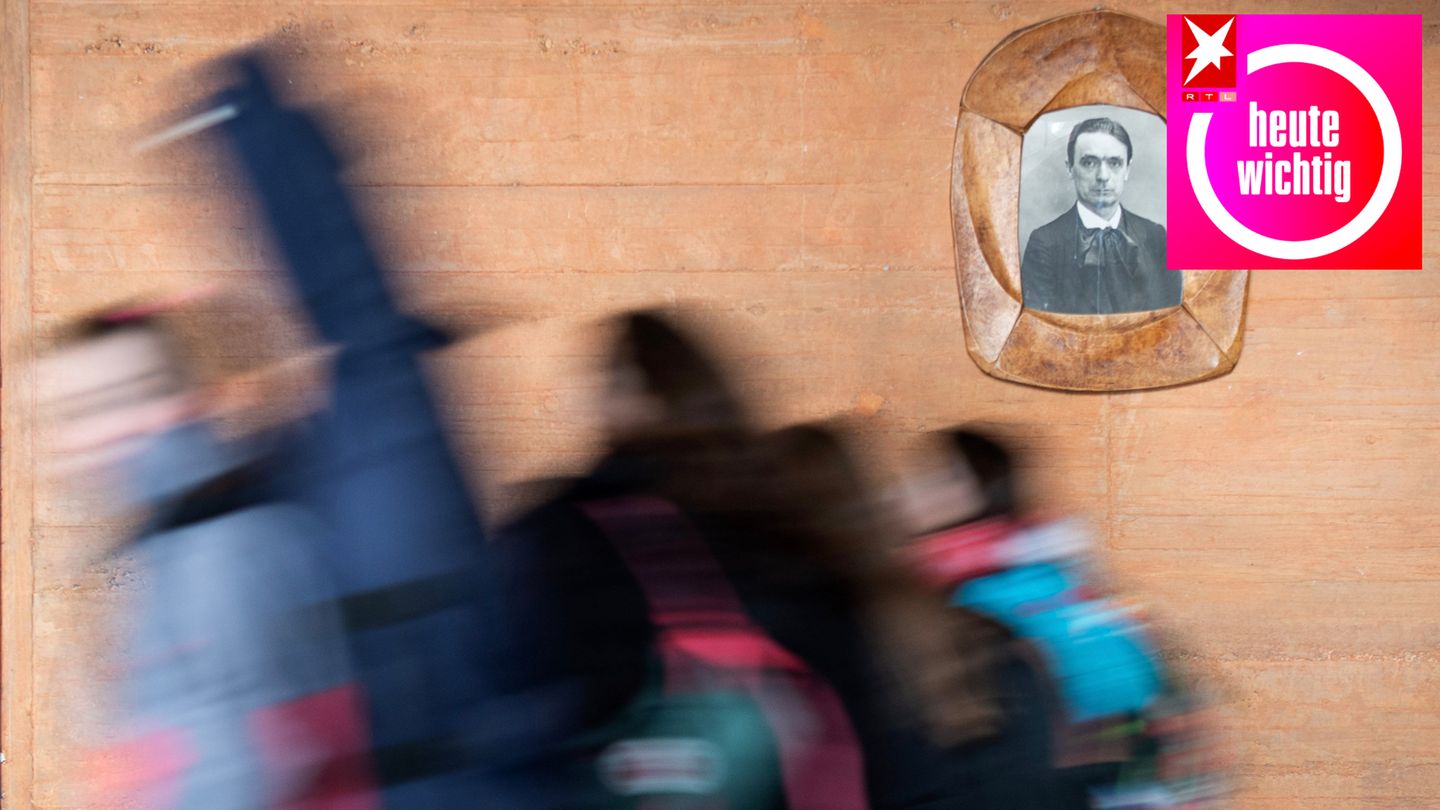Schülerinnen gehen in der Freien Waldorfschule Uhlandshöhe an einem Bild von Rudolf Steiner vorbei