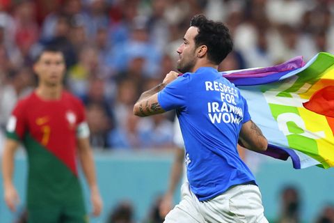 Ein Flitzer mit der Regenbogenflagge läuft über den Rasen des Lusail Iconic Stadions.