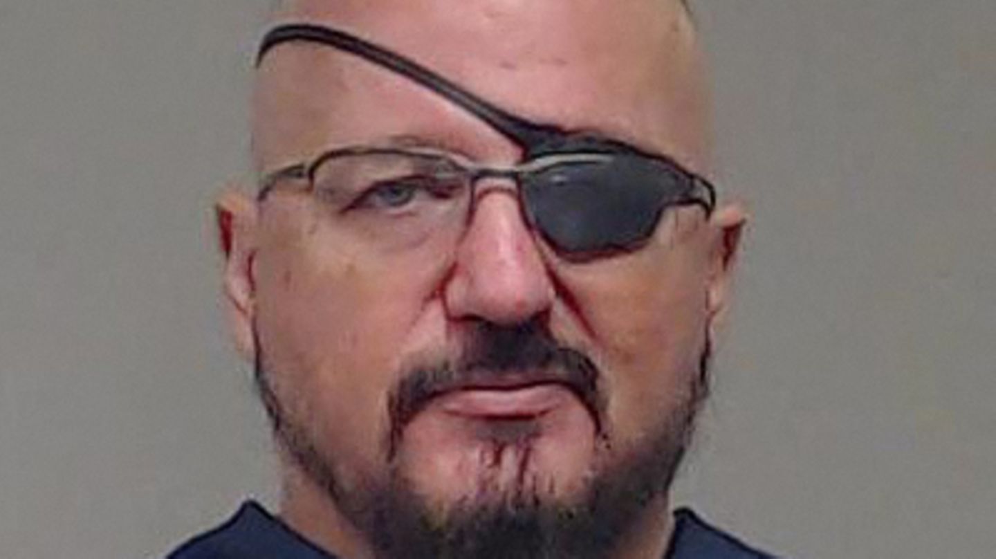Ein weißer Mann mit Vollbart, Brille und Augenklappe über seinem linken Auge schaut direkt in die Kamera