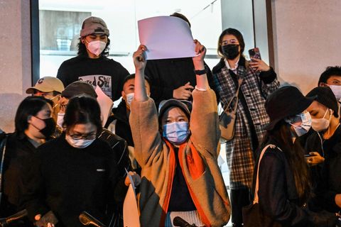 Eine Demonstrantin hält in Shanghai ein weißes Blatt Papier in die Luft.