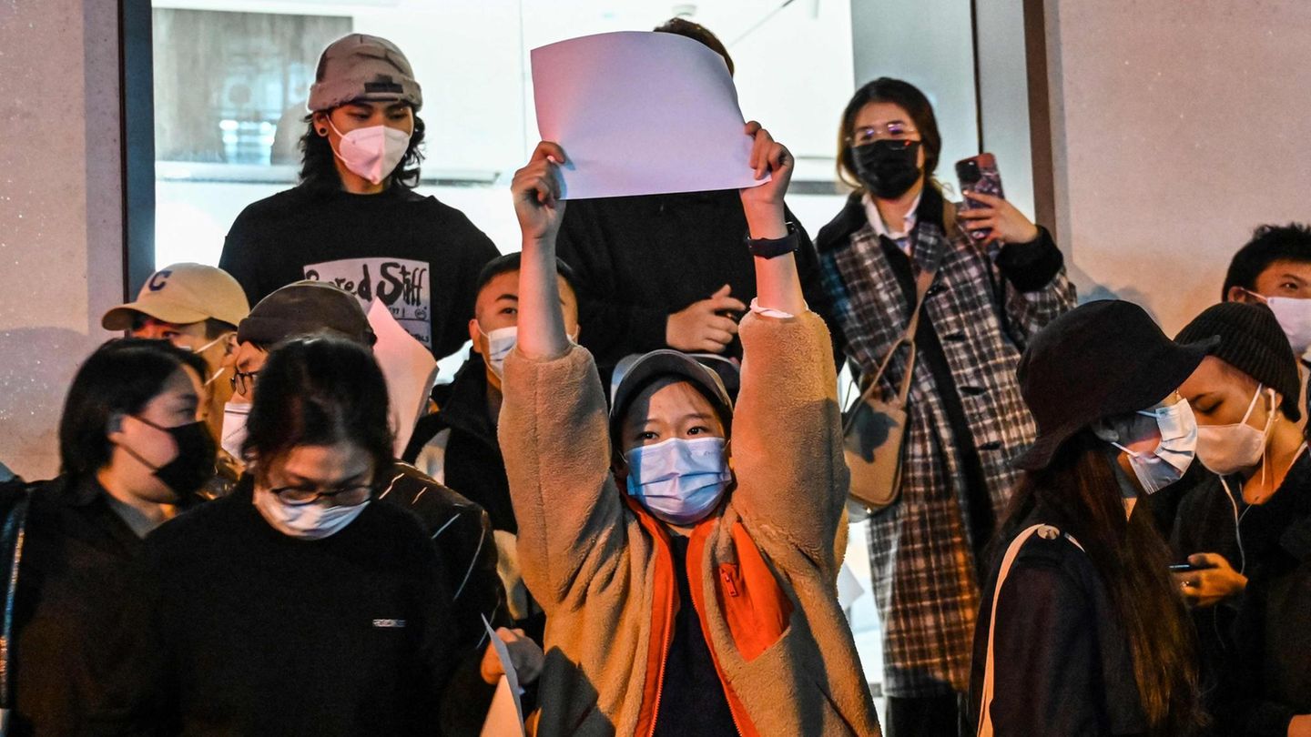 Eine Demonstrantin hält in Shanghai ein weißes Blatt Papier in die Luft.