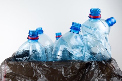 Plastikflaschen ragen aus schwarzem Müllbeutel