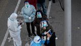 Peking, China. Menschen stehen in der chinesischen Metropole für einen PCR-Tests Schlange. Obwohl die Tests im Freien statfinden, tragen die Menschen FFP2-Masken und Plastikvisiere. Über allem steht die Frage: Wann hat es sich in China ausgetestet?