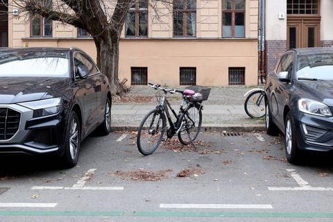 In einer Parklücke zwischen zwei Autos steht ein Fahrrad