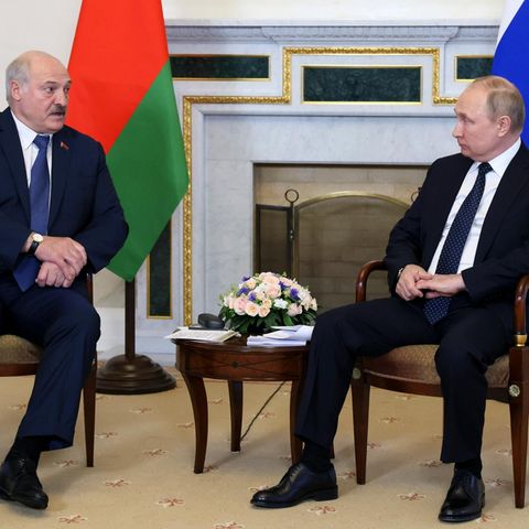 Putin und Lukaschenko stehen nebeneinander und geben sich die Hand