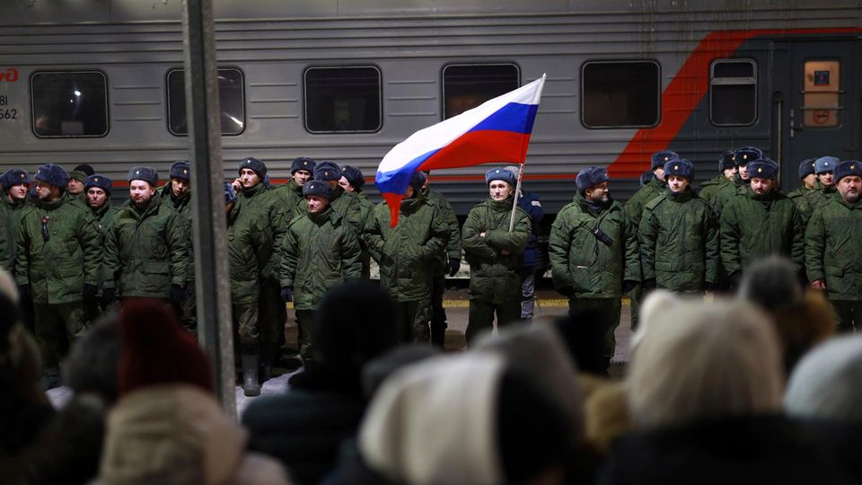 Soldaten stehen bei einer Zeremonie vor dem Einsteigen in einen Zug auf einem Bahnhof