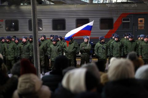 Soldaten stehen bei einer Zeremonie vor dem Einsteigen in einen Zug auf einem Bahnhof