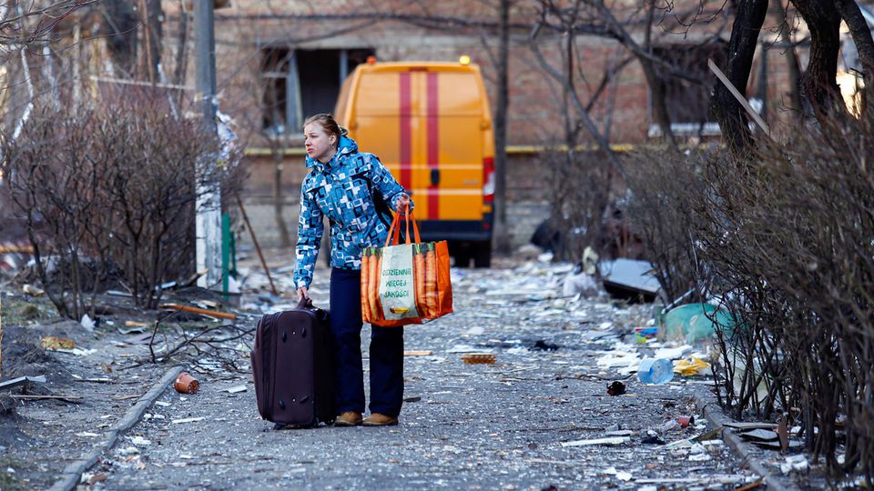 Eine Frau verlässt ihr Zuhause nach einem russischen Angriff