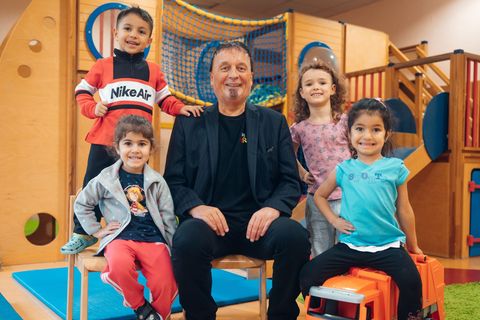 Der Leiter der Arche umgeben von vier kleinen Kindern