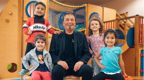 Der Leiter der Arche umgeben von vier kleinen Kindern