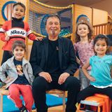 Der Leiter der Arche umgeben von vier kleinen Kindern