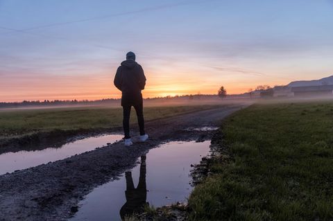 Michael Koch geht im bayerischen Voralpenland auf einem Weg entlang