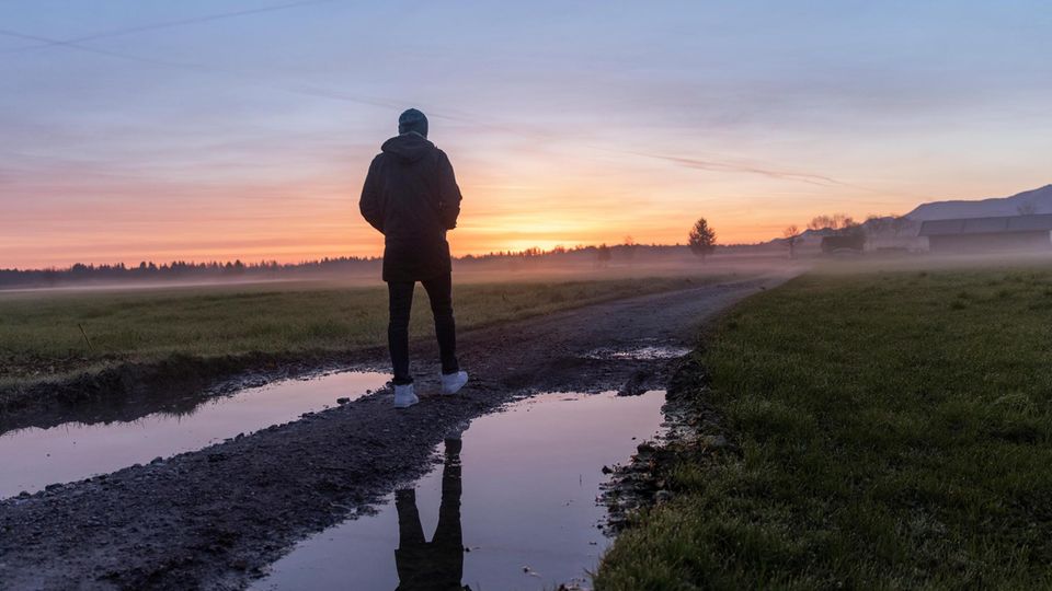 Michael Koch geht im bayerischen Voralpenland auf einem Weg entlang
