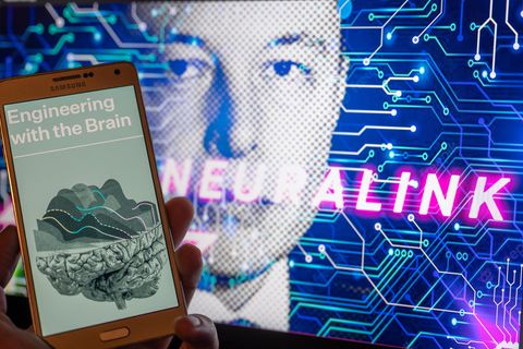 Ein Smartphone zeigt ein Bild eines Gehirns mit Elon Musk im Hintergrund