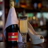 Eine Flasche Champagner, ein Glas French '75 und ein Highheel