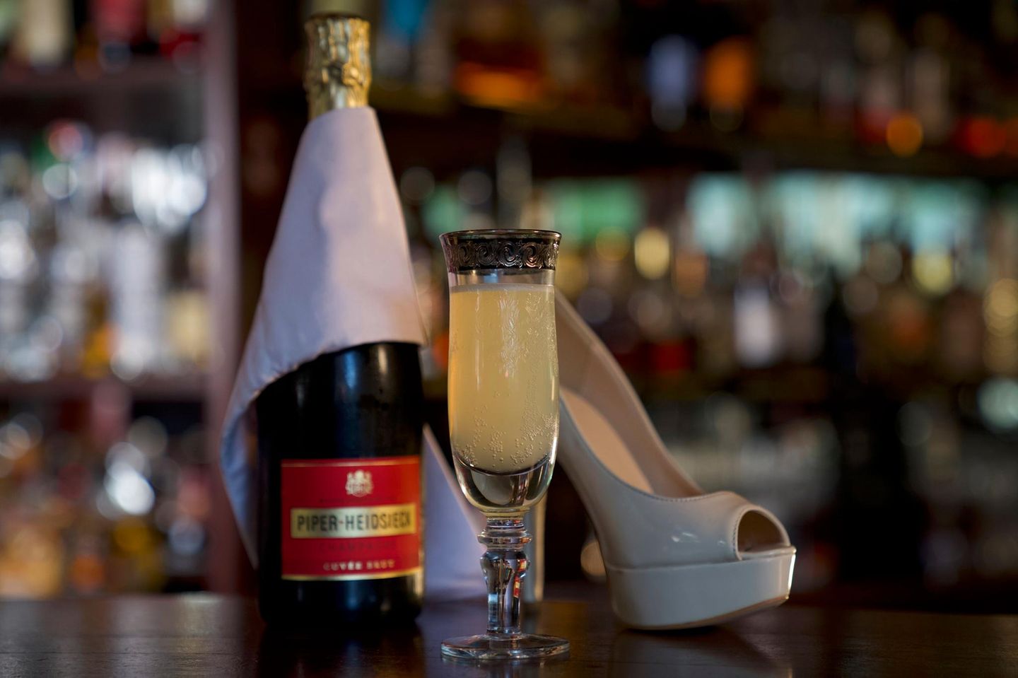 Eine Flasche Champagner, ein Glas French '75 und ein Highheel