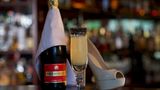 Eine Flasche Champagner, ein Glas French '75 und ein Highheel