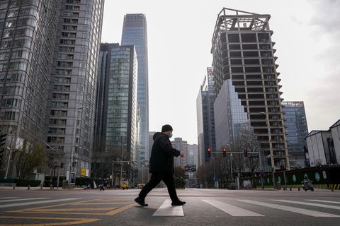 Ein Mann geht durch fast leere Straßen in Peking