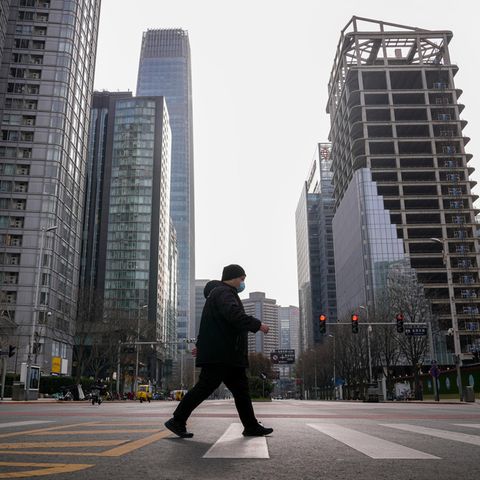 Ein Mann geht durch fast leere Straßen in Peking