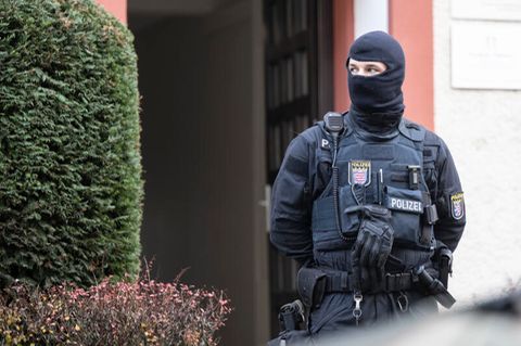 Bei einer Razzia gegen sogenannte Reichsbürger sichert ein Polizist ein durchsuchtes Objekt in Frankfurt
