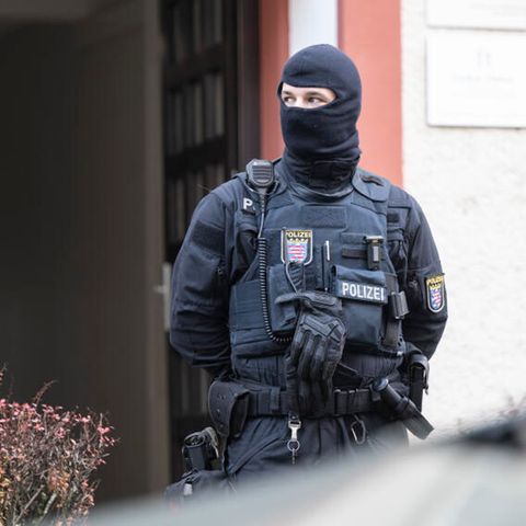 Bei einer Razzia gegen sogenannte Reichsbürger sichert ein Polizist ein durchsuchtes Objekt in Frankfurt