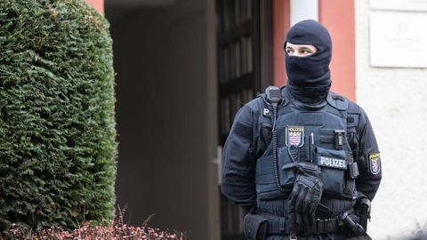 Bei einer Razzia gegen sogenannte Reichsbürger sichert ein Polizist ein durchsuchtes Objekt in Frankfurt
