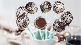 Spekulatius-Cakepops  Für den Teig:  200 g Gewürzspekulatius, 60 g veganer Frischkäse auf Mandelbasis, 8 g Vanillezucker  Außerdem: 100 g weiße vegane Schokodrops, 1 EL Himbeerpulver, ca. 12 TL Schokostreusel (ca. 35 g),  12 Cakepop-Stiele      Zubereitung:  Für den Teig den Spekulatius in einer Küchenmaschine zerkleinern und in eine Schüssel füllen. Den Frischkäse und den Vanillezucker hinzugeben. Mit den Händen alles gut verkneten und 12 kleine Bällchen formen.  Die Schokodrops auf einem heißen Wasserbad schmelzen und das Himbeerpulver einrühren. Jeweils einen Cakepop-Stiel 1 cm tief in die flüssige Schokolade stecken, dann den schokolierten Bereich in jeweils ein Bällchen stecken. Den Vorgang für alle Bällchen wiederholen.  Die Bällchen am Stiel nun nacheinander vorsichtig in die flüssige Schokolade tauchen. Mit einem Löffel die Schokolade gleichmäßig verteilen. Die überschüssige Schokolade über der Schüssel abtropfen lassen, die Cakepops in ein Glas stellen, mit jeweils 1 TL Schokostreusel dekorieren und trocknen lassen.