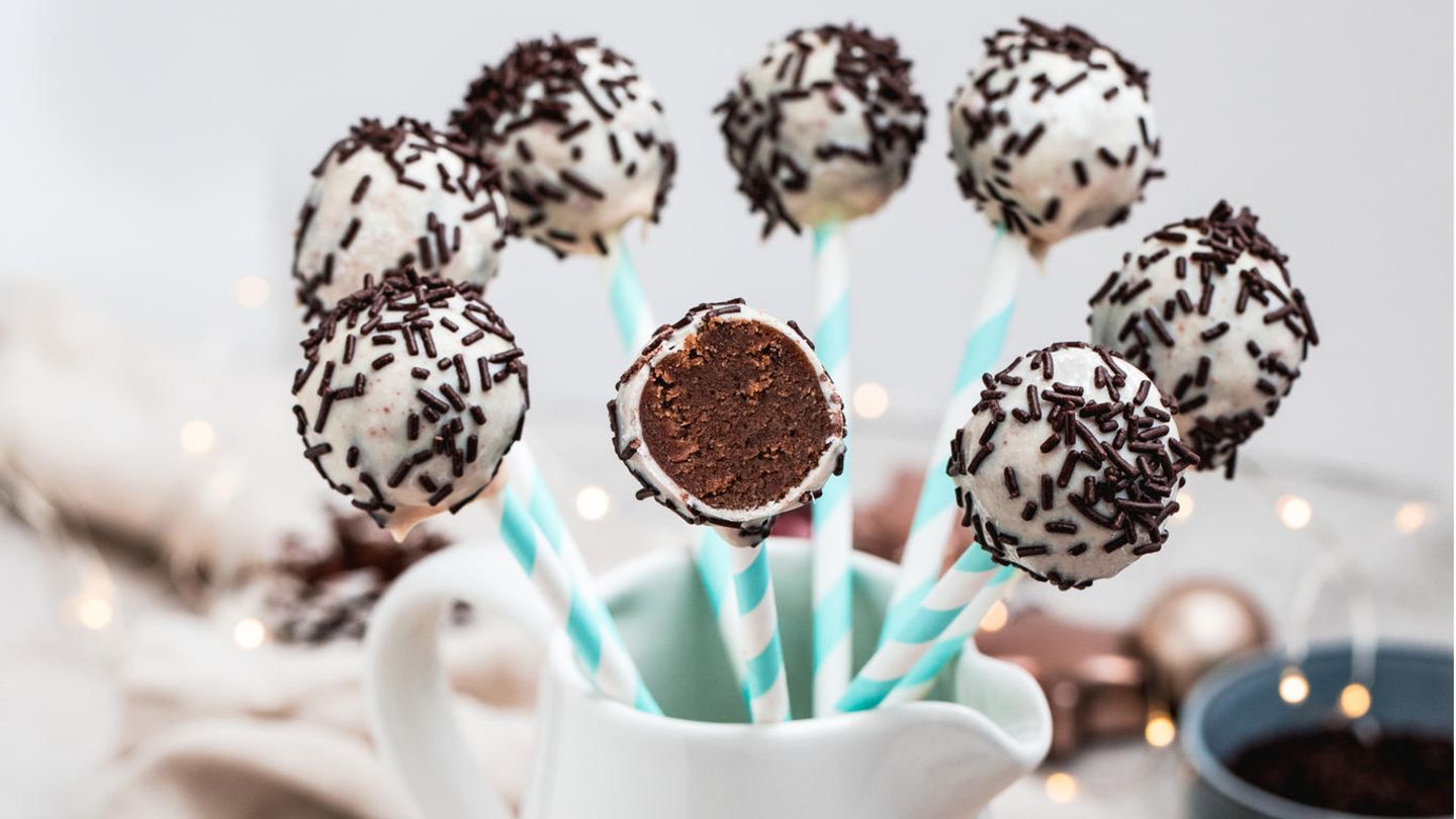 Vegane Weihnachten: Spekulatius-Cakepops Für den Teig: 200 g Gewürzspekulatius, 60 g veganer Frischkäse auf Mandelbasis, 8 g Vanillezucker Außerdem: 100 g weiße vegane Schokodrops, 1 EL Himbeerpulver, ca. 12 TL Schokostreusel (ca. 35 g), 12 Cakepop-Stiele Zubereitung: Für den Teig den Spekulatius in einer Küchenmaschine zerkleinern und in eine Schüssel füllen. Den Frischkäse und den Vanillezucker hinzugeben. Mit den Händen alles gut verkneten und 12 kleine Bällchen formen. Die Schokodrops auf einem heißen Wasserbad schmelzen und das Himbeerpulver einrühren. Jeweils einen Cakepop-Stiel 1 cm tief in die flüssige Schokolade stecken, dann den schokolierten Bereich in jeweils ein Bällchen stecken. Den Vorgang für alle Bällchen wiederholen. Die Bällchen am Stiel nun nacheinander vorsichtig in die flüssige Schokolade tauchen. Mit einem Löffel die Schokolade gleichmäßig verteilen. Die überschüssige Schokolade über der Schüssel abtropfen lassen, die Cakepops in ein Glas stellen, mit jeweils 1 TL Schokostreusel dekorieren und trocknen lassen. Spekulatius-Cakepops Für den Teig: 200 g Gewürzspekulatius, 60 g veganer Frischkäse auf Mandelbasis, 8 g Vanillezucker Außerdem: 100 g weiße vegane Schokodrops, 1 EL Himbeerpulver, ca. 12 TL Schokostreusel (ca. 35 g), 12 Cakepop-Stiele Zubereitung: Für den Teig den Spekulatius in einer Küchenmaschine zerkleinern und in eine Schüssel füllen. Den Frischkäse und den Vanillezucker hinzugeben. Mit den Händen alles gut verkneten und 12 kleine Bällchen formen. Die Schokodrops auf einem heißen Wasserbad schmelzen und das Himbeerpulver einrühren. Jeweils einen Cakepop-Stiel 1 cm tief in die flüssige Schokolade stecken, dann den schokolierten Bereich in jeweils ein Bällchen stecken. Den Vorgang für alle Bällchen wiederholen. Die Bällchen am Stiel nun nacheinander vorsichtig in die flüssige Schokolade tauchen. Mit einem Löffel die Schokolade gleichmäßig verteilen. Die überschüssige Schokolade über der Schüssel abtropfen lassen, die Cakepops in ein Glas stellen, mit jeweils 1 TL Schokostreusel dekorieren und trocknen lassen.