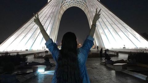 Frau ohne Kopftuch vor dem Azadi Turm in Teheran
