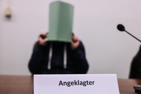 Der Angeklagte im Missbrauchskomplex Wermelskirchen hält sich im Gerichtssaal eine Mappe vor das Gesicht