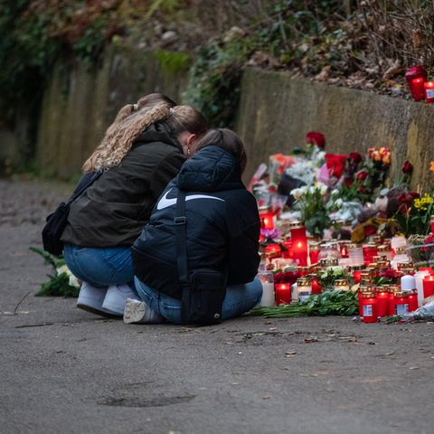 Drei Mädchen trauern am Tatort eines Messerangriffs in Illerkirchberg auf zwei Schülerinnen