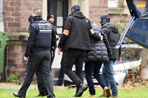 Eine Person (2.v.r.) wird von Polizisten aus einem Hubschrauber gebracht