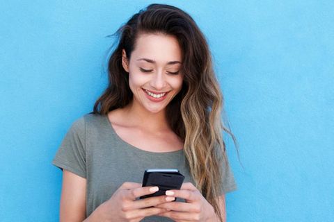 Frau mit Smartphone nutzt Whatsapp