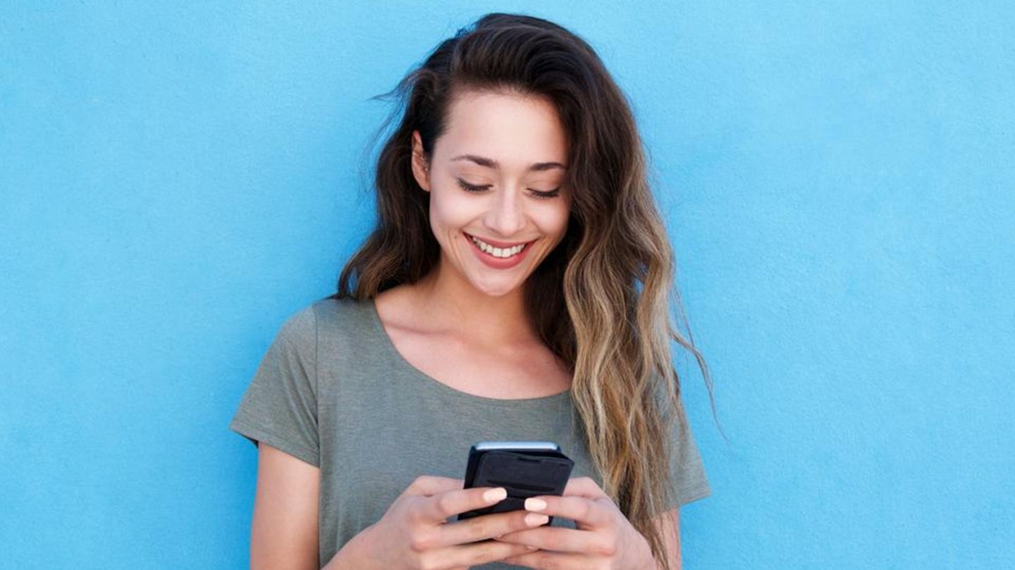 Frau mit Smartphone nutzt Whatsapp