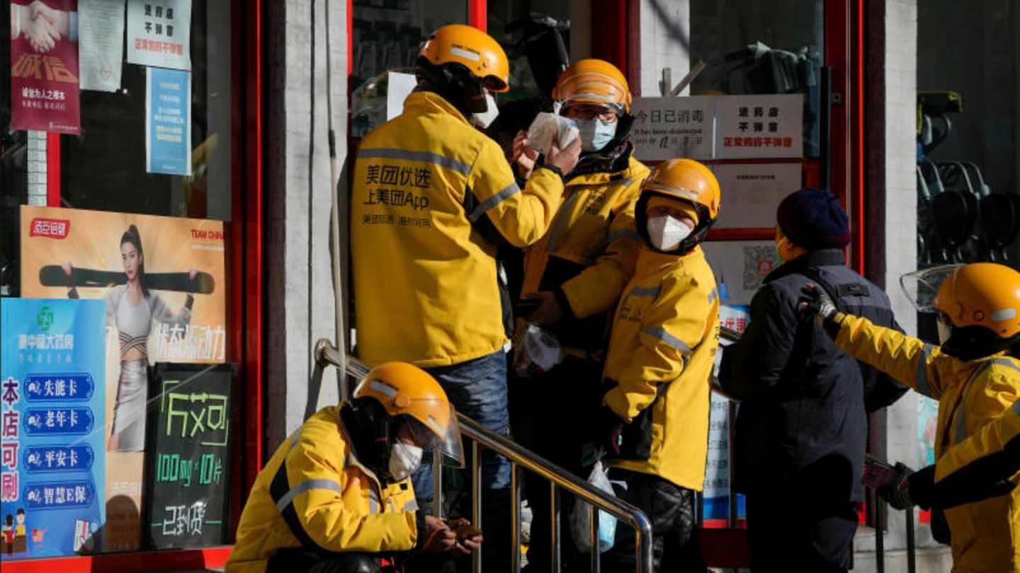 Vor einer Apotheke in Peking stehen Zusteller Schlange