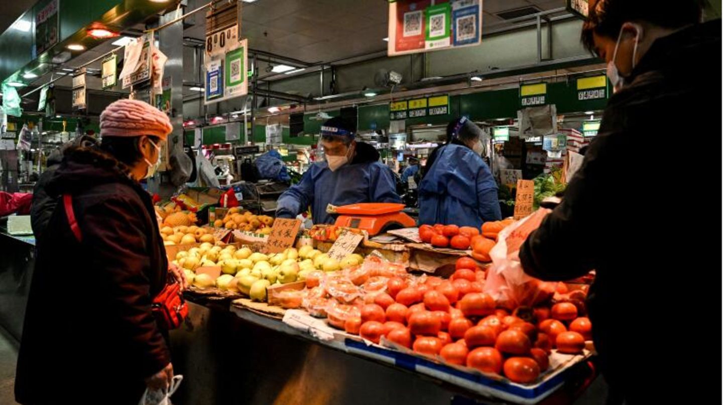 Eine Frau kauft Gemüse auf einem Wochenmarkt in Peking.