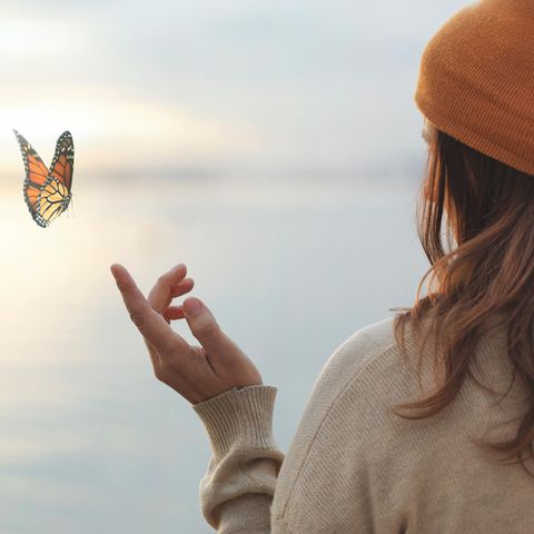 A woman lets a butterfly land on her finger