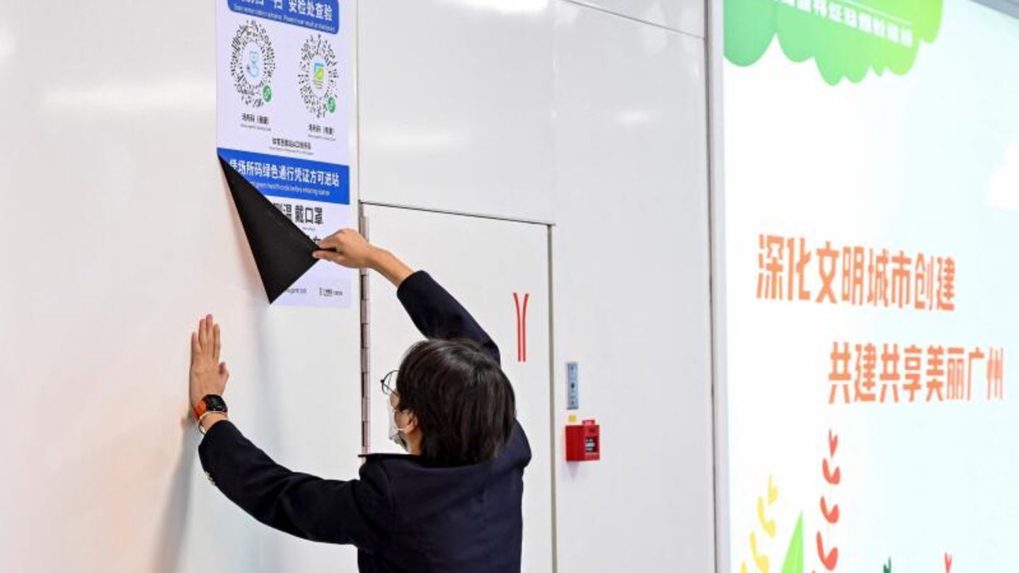 Ein Mitarbeiter entfernt in einer U-Bahn-Station in der südchinesischen Stadt Guangzhou ein Plakat,