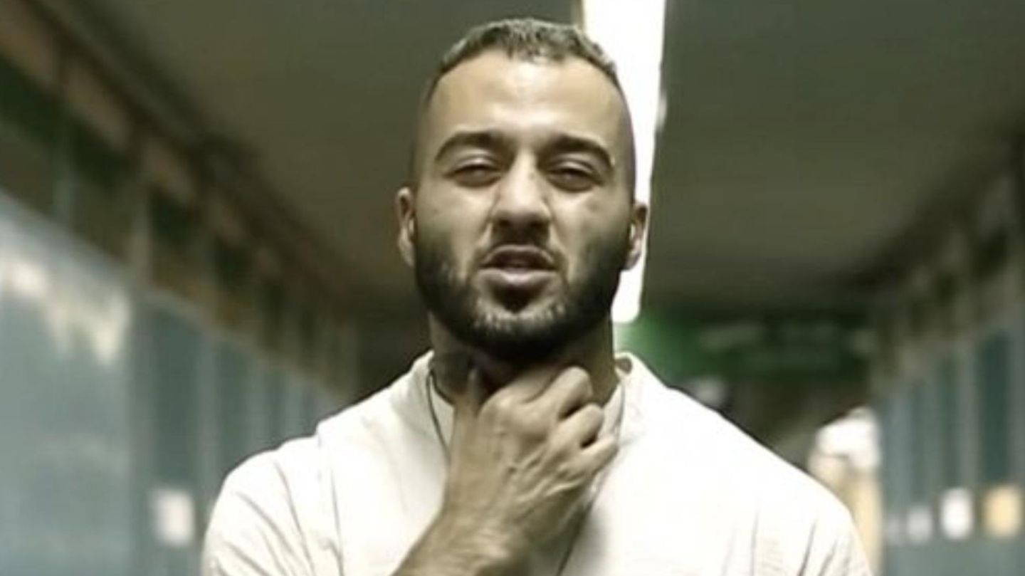 Toomaj Salehi hält sich die Hand an den Hals in einem Musikvideo