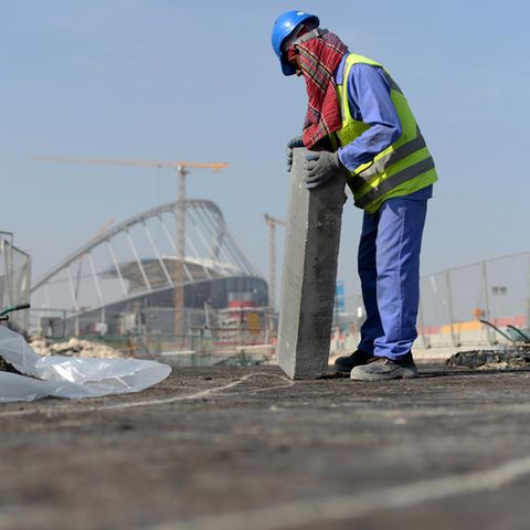 Ein Gastarbeiter bringt am 11.01.2017 an einer Straße vor dem Khalifa-Stadion in Doha, Katar