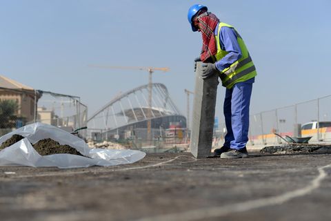 Ein Gastarbeiter bringt am 11.01.2017 an einer Straße vor dem Khalifa-Stadion in Doha, Katar