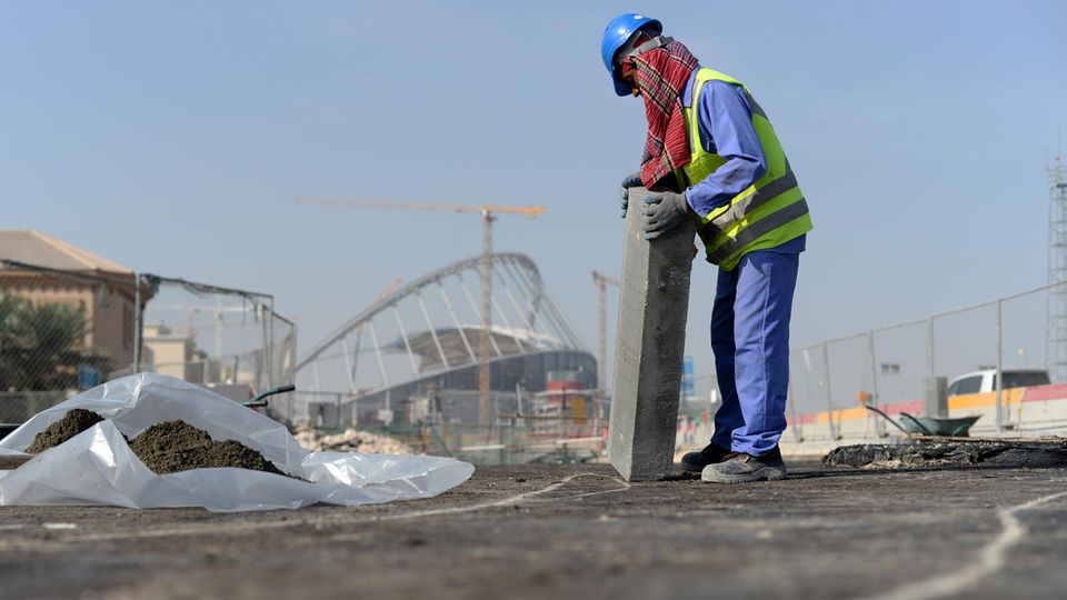 Ein Gastarbeiter bringt am 11.01.2017 an einer Straße vor dem Khalifa-Stadion in Doha, Katar