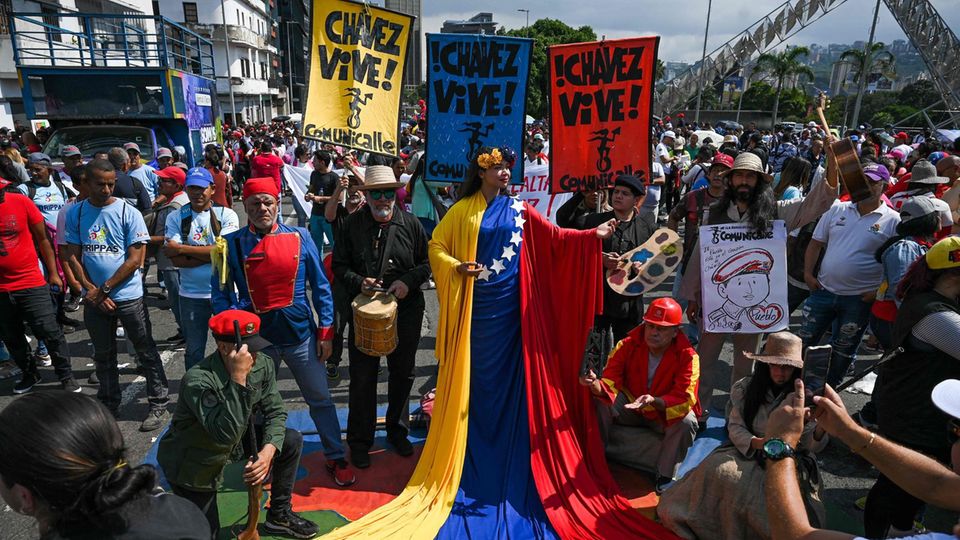 Caracas, Venezuela. Zusammen mit zahlreichen Maduro-Unterstützern nimmt diese als Freiheitsstatue gekleidete Frau an einem Marsch zum Gedenken an den verstorbenen Ex-Präsidenten Hugo Chavez teil. Sie nennen es "den Tag der Loyalität und Liebe für Kommandant Hugo Chavez".