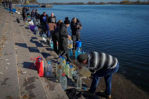 Menschen füllen Wasser aus dem Fluss Dnipro in Kanister