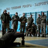 Roo erläutert in der umfunktionierten Turnhalle der Schule die Entschärfung von besonders gefährlichen Anti-Personenminen. Die O3M-72 wird mit einem Stolperdraht ausgelöst, der im hohen Gras kaum sichtbar ist