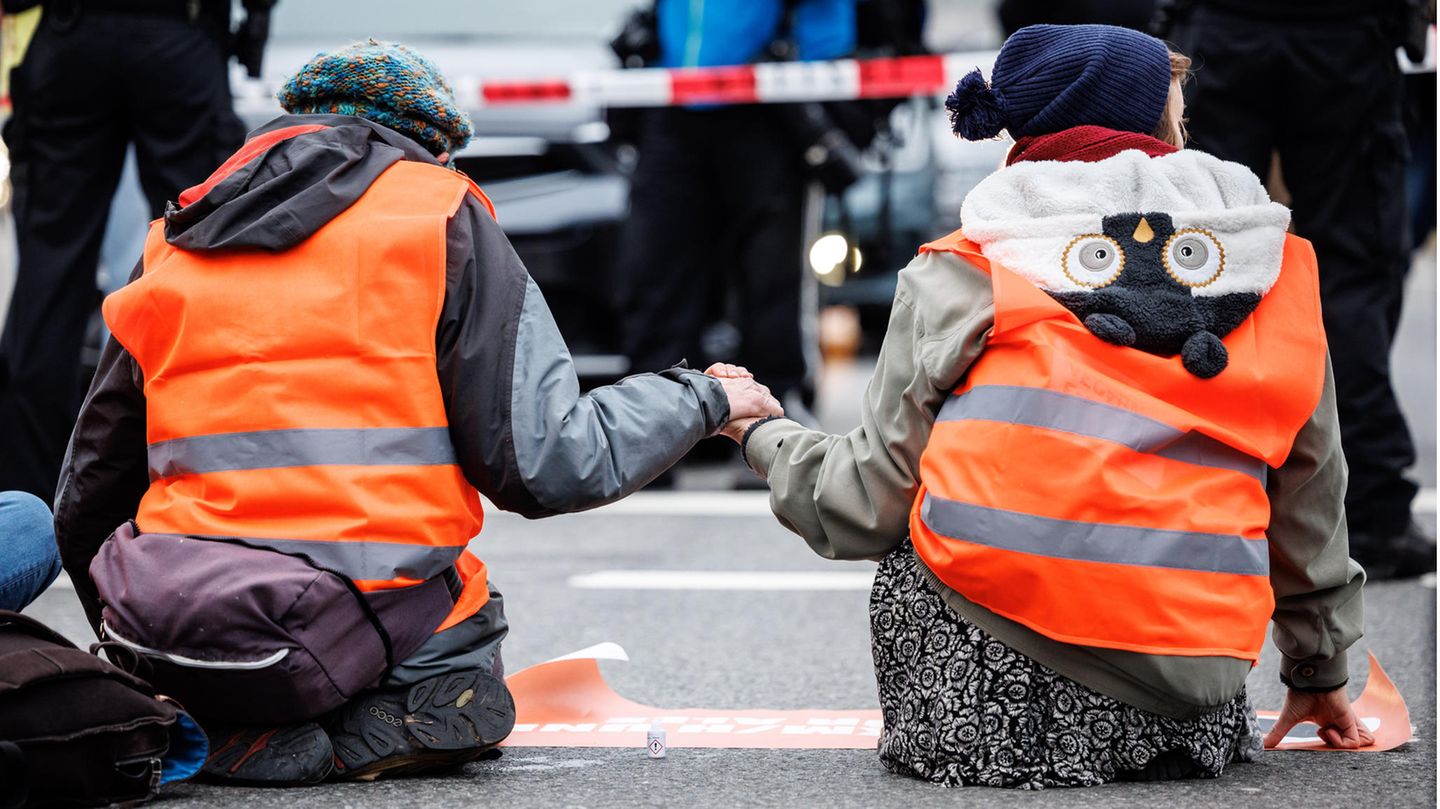 Aktivisten der Klimaschutz-Initiative "Letzte Generation" haben sich mit ihren Händen auf die Straße geklebt