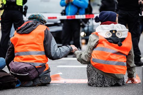 Aktivisten der Klimaschutz-Initiative "Letzte Generation" haben sich mit ihren Händen auf die Straße geklebt