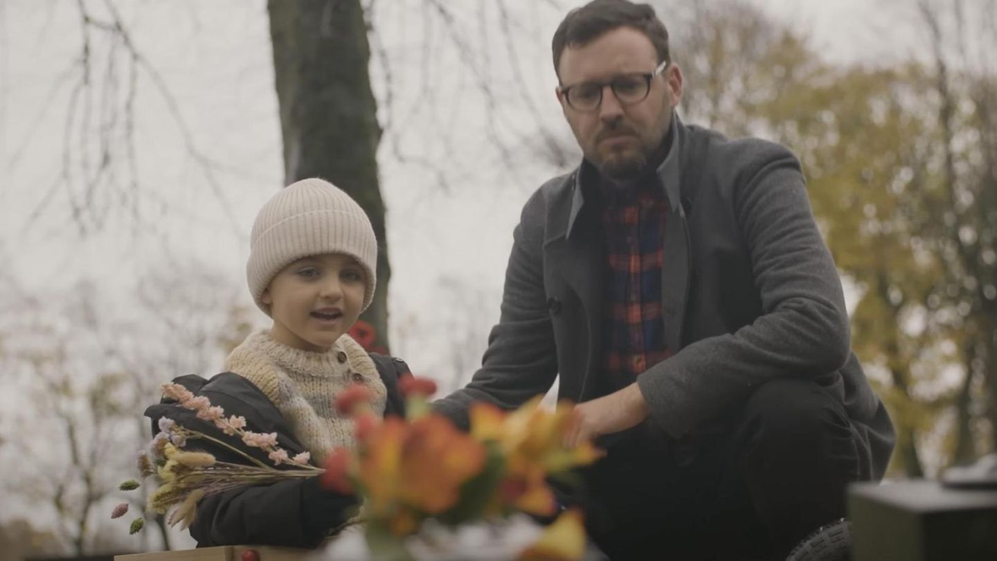 Vater und Sohn am Grab der Mutter