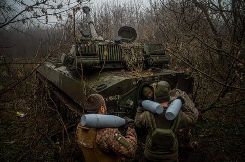 Ukrainische Soldaten laden Munition in eine Panzerhaubitze 